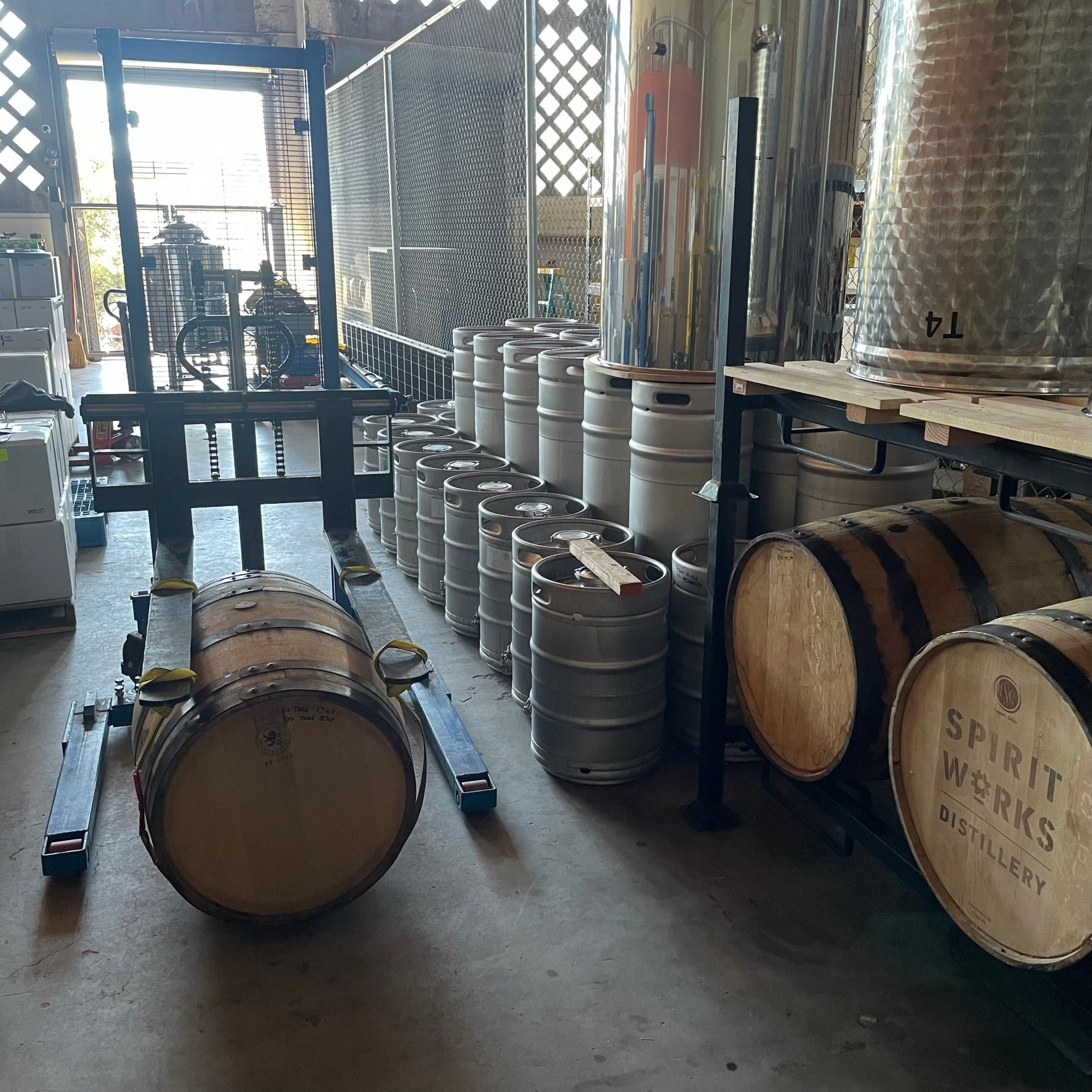 Casks, kegs, and tanks in a room at Spirit Works Distillery. 