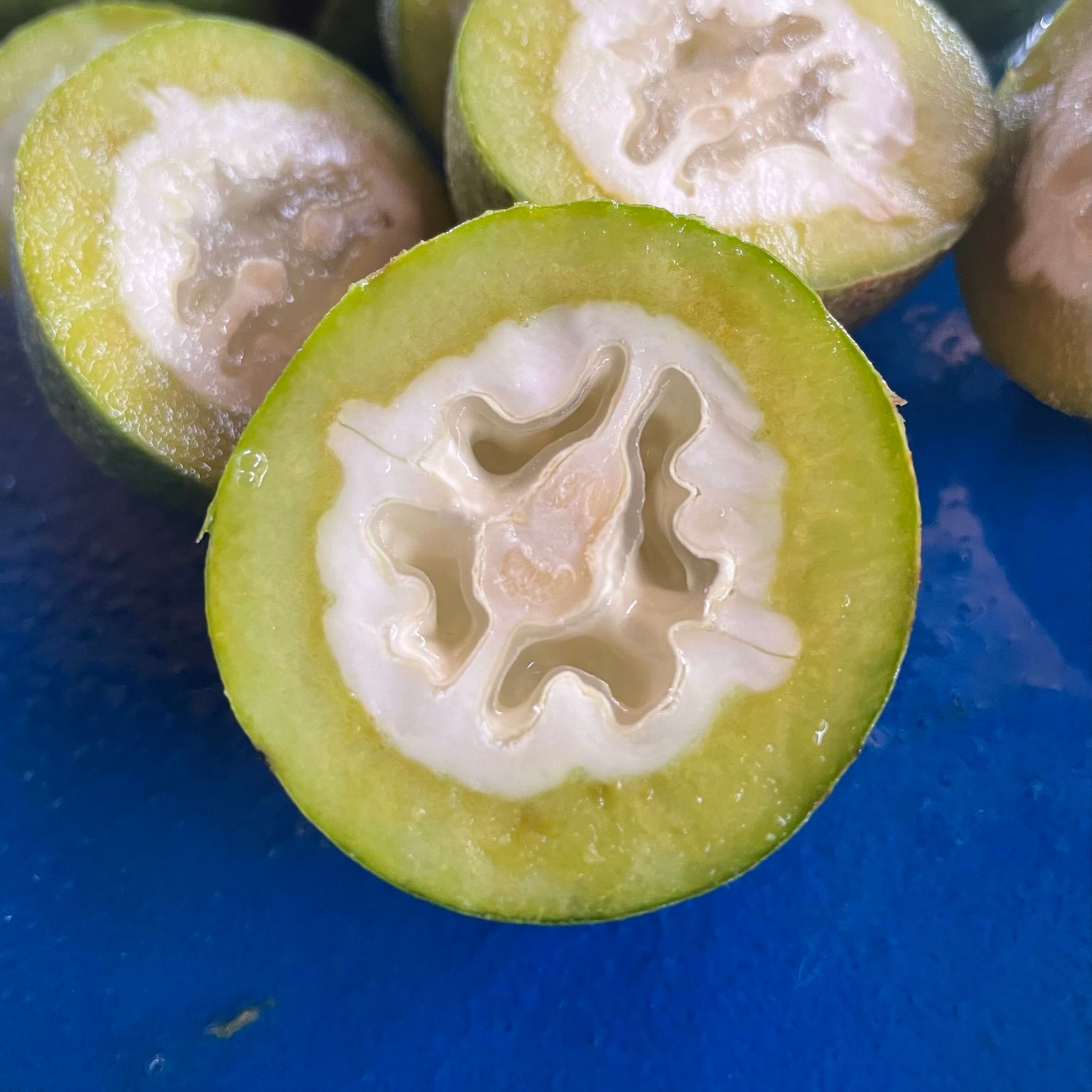 A close-up photo of halved green walnuts.