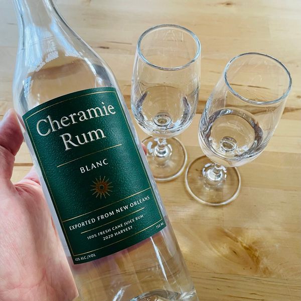 A bottle of Cheramie Rum Blanc with two tasting glasses.